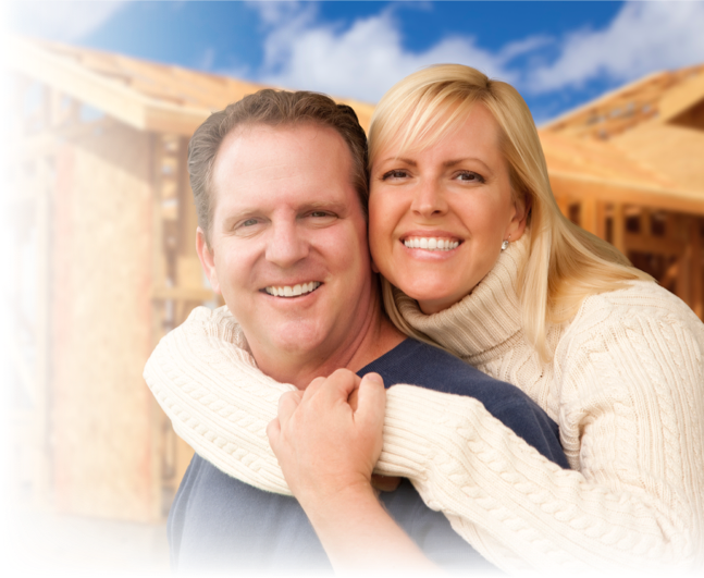 Man and woman hugging in front of their home construction project